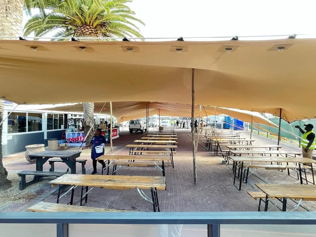 Beer bench tables and benches beneath a stretch tent